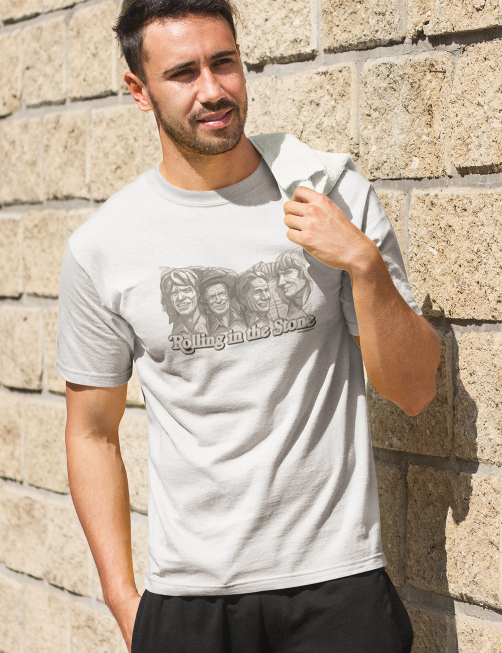 Uomo divertente che rotola nella maglietta di pietra